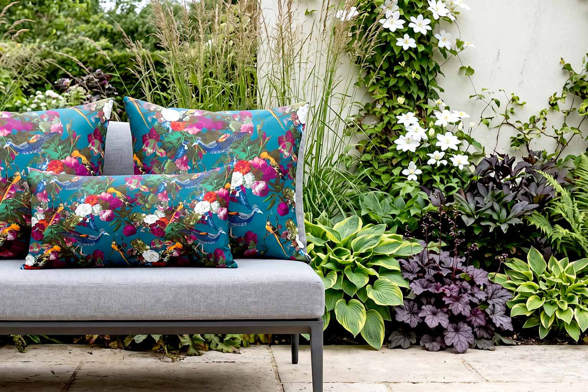 Teal Manor House Garden bird outdoor cushions on a contemporary grey garden sofa.