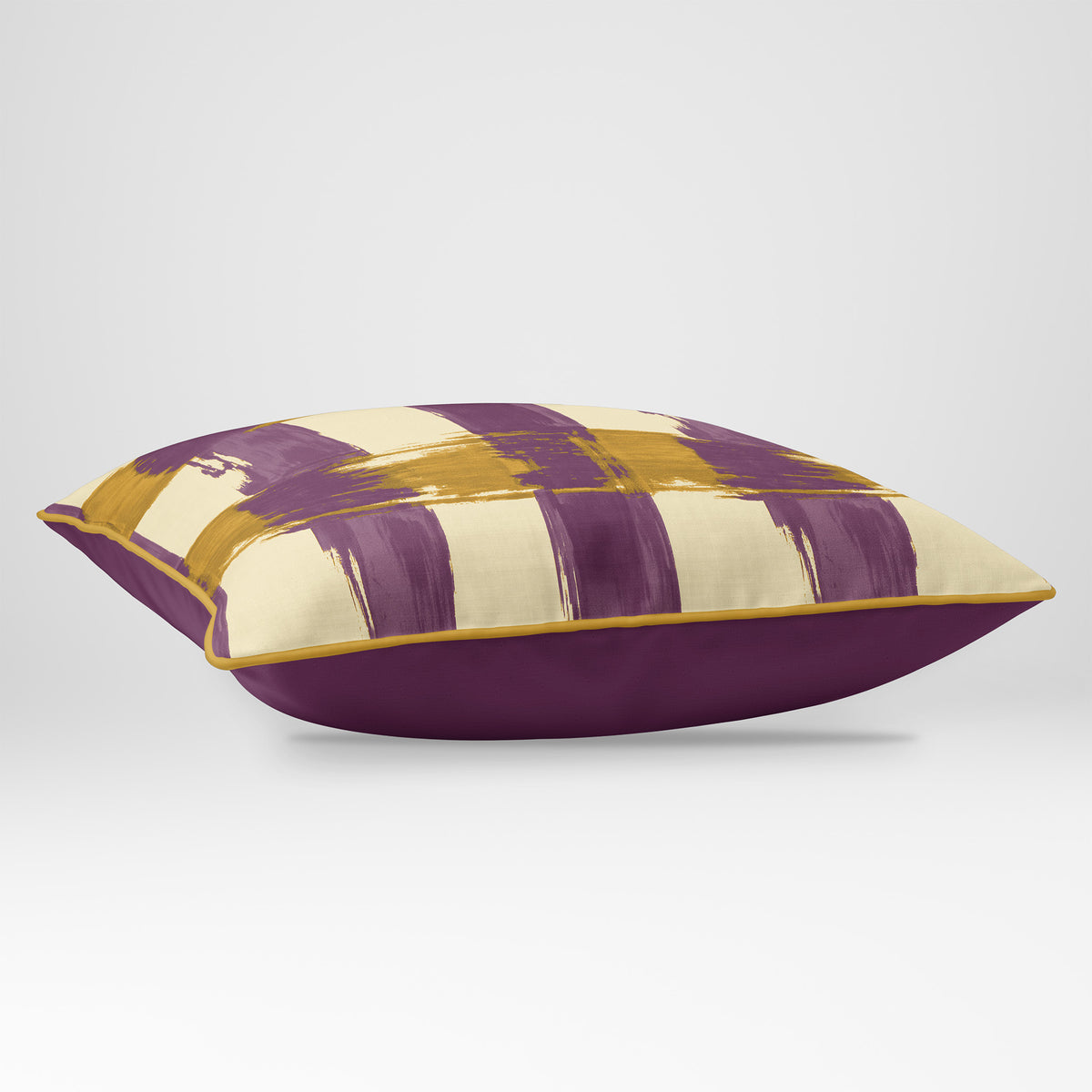 Angled view showing the front and Rich Plum plain reverse of a Broad Check rectangular cushion in Plum & Saffron, finished with Saffron piping.