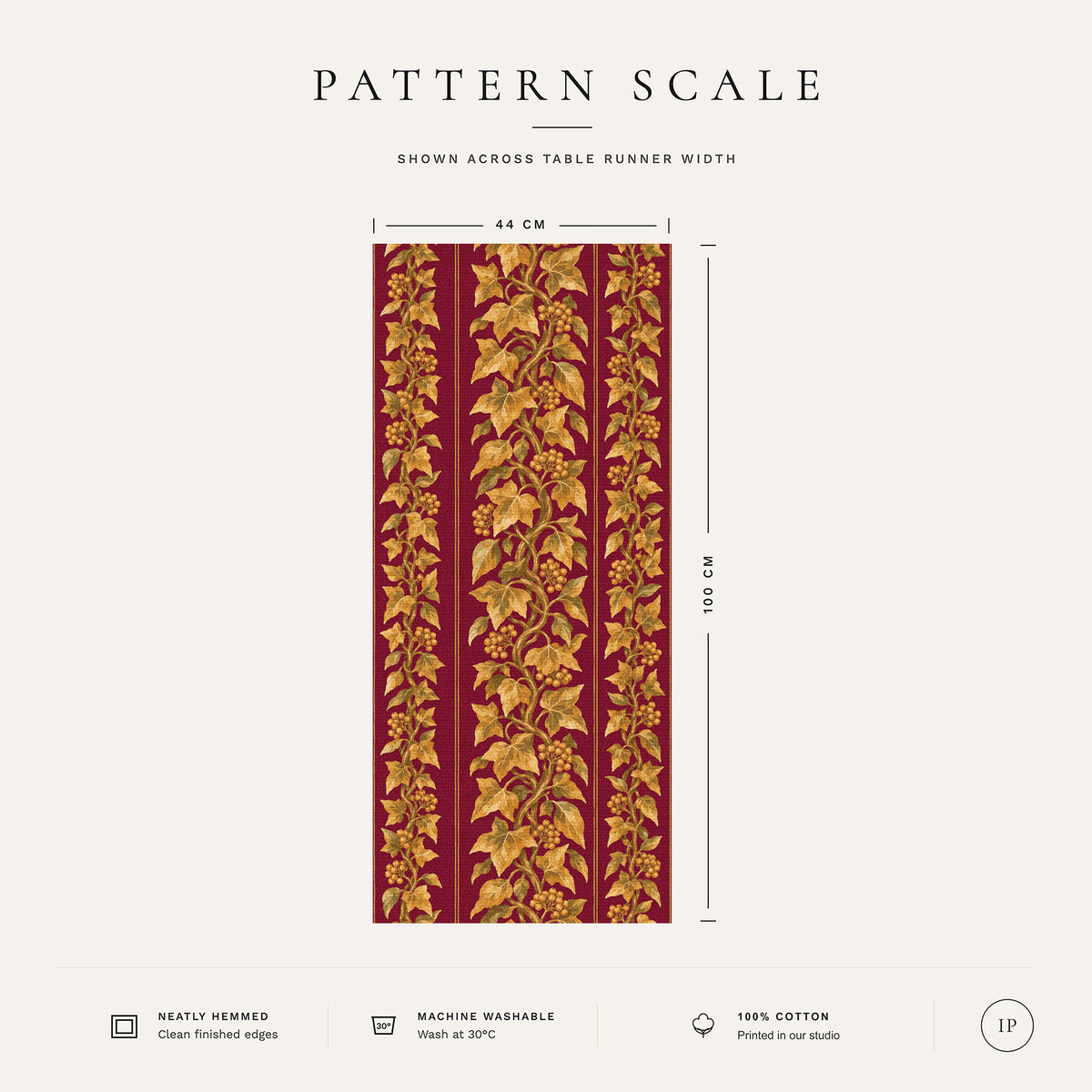 Pattern scale of the Gilded Ivy Christmas table runner in burgundy and gold across its 44 cm width, with care notes