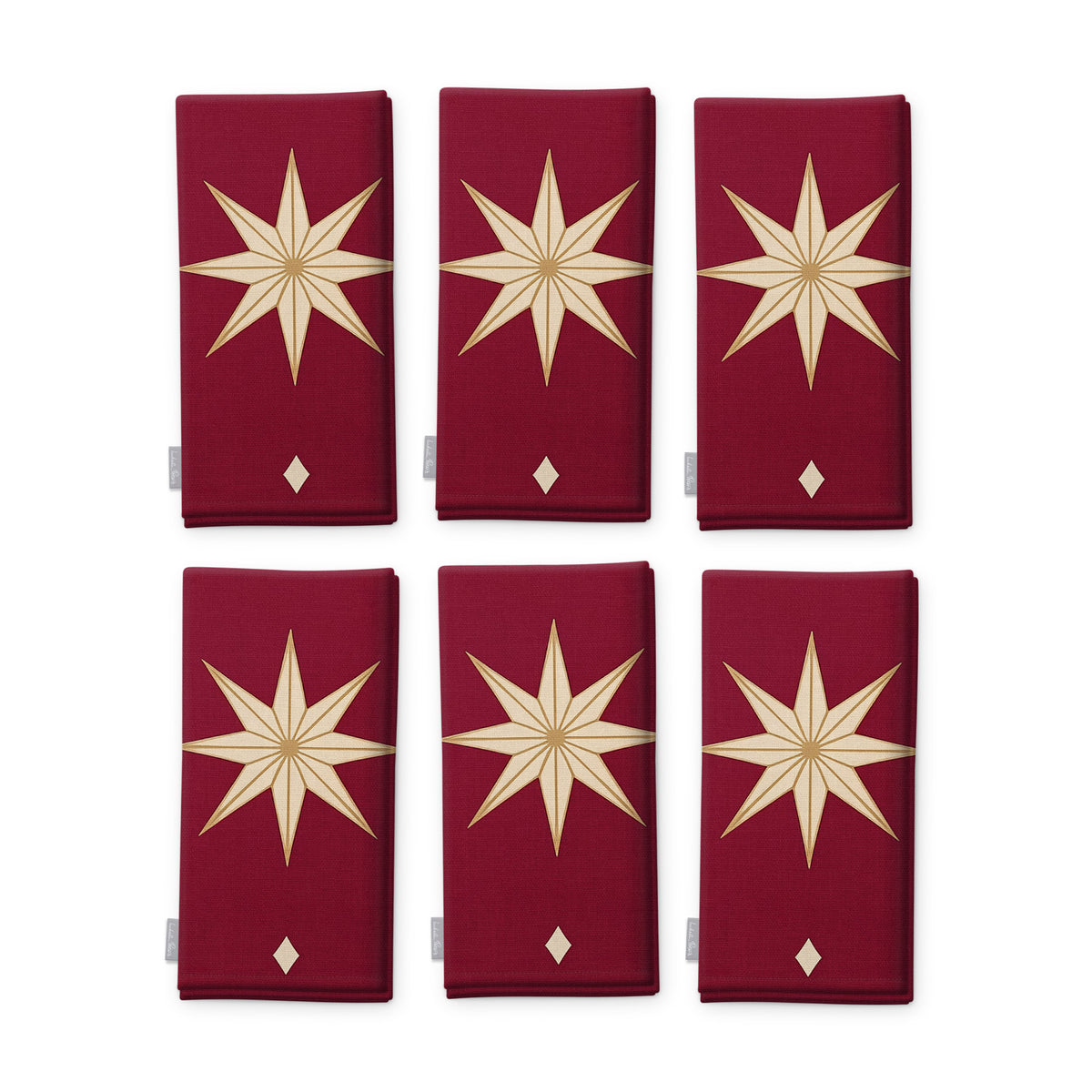 Stars Christmas napkins in burgundy and gold, set of six, folded on white, showing the same large gold eight-pointed star