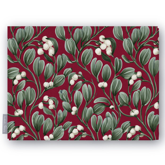 Burgundy Mistletoe Christmas tablecloth folded on white, showing sprigs of mistletoe with white berries