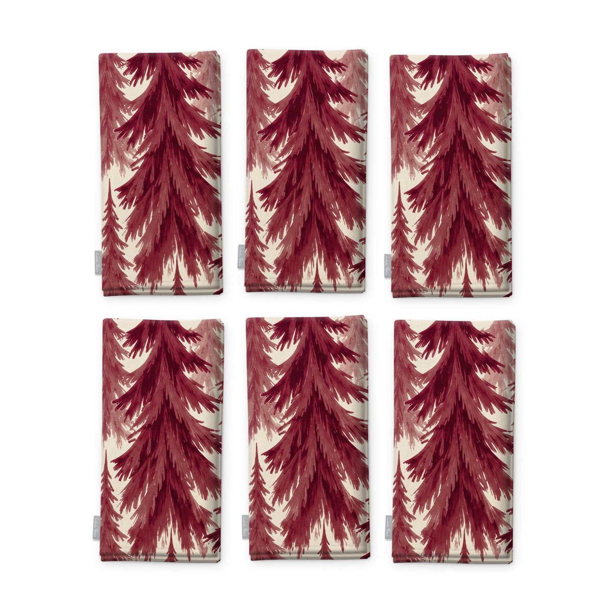 Spruce Stand Christmas napkins in burgundy on ivory, set of six, folded on white, showing the same spruce trees