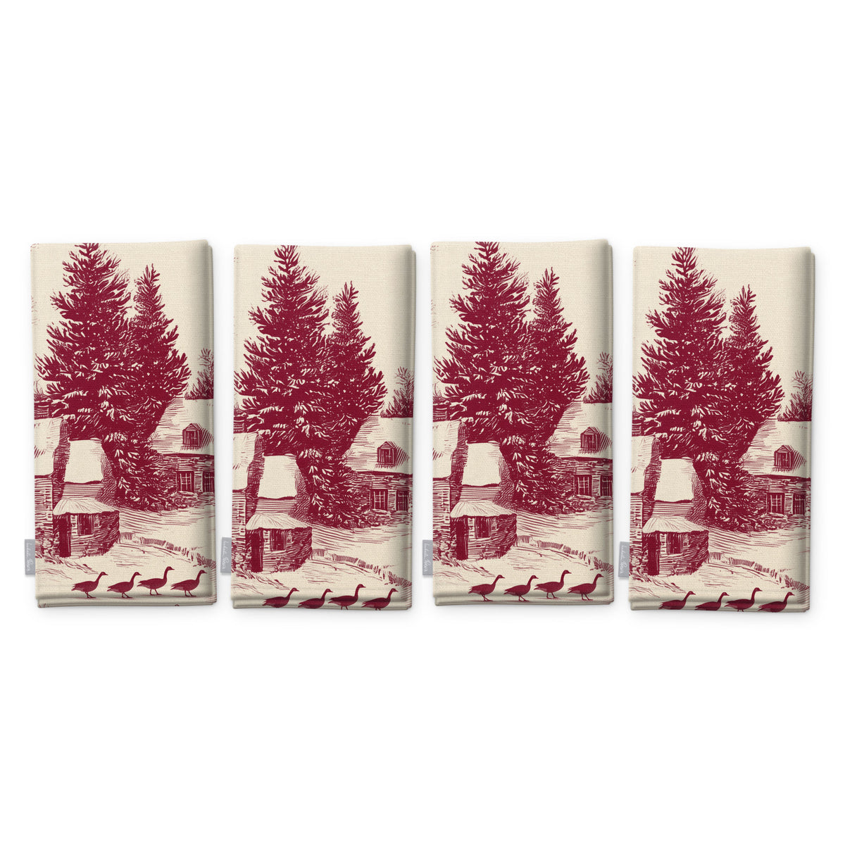Village Toile napkins in burgundy on ivory, set of four, folded on white, showing the same fir tree and snowy cottage