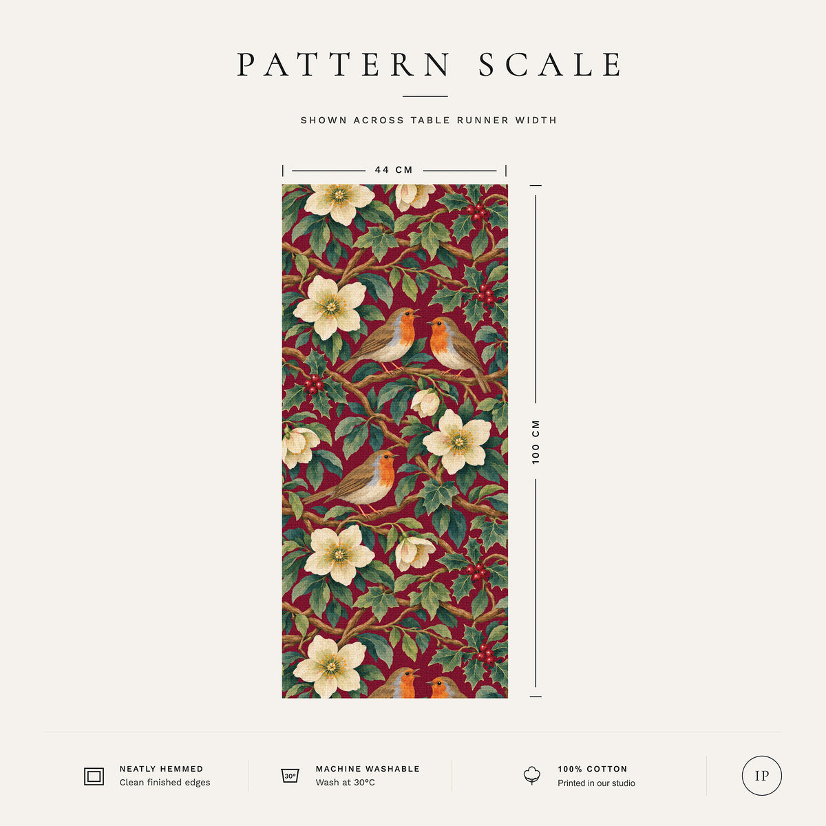 Pattern scale of the Robins and Christmas Roses Christmas table runner in burgundy across its 44 cm width, with care notes