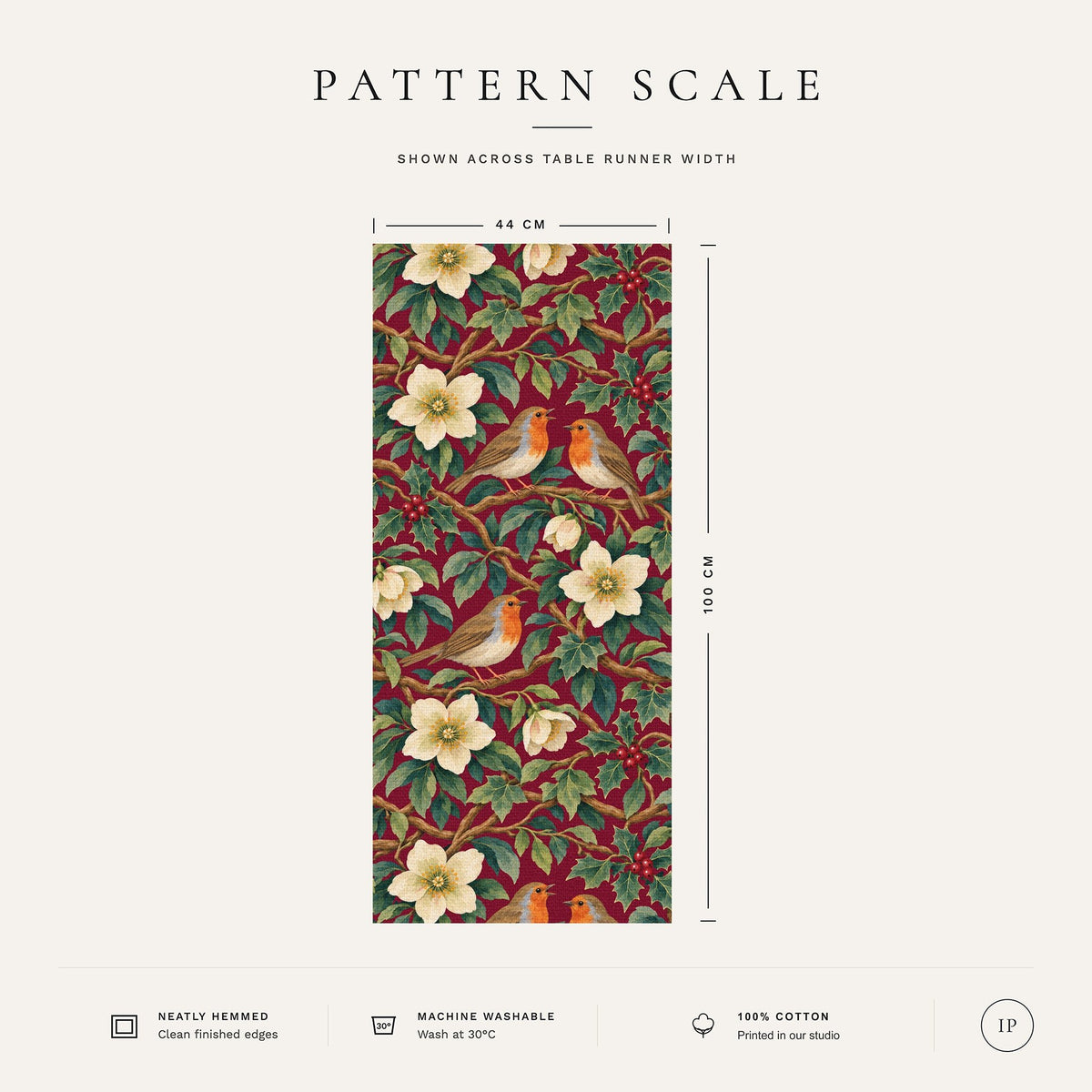 Pattern scale of the Robins and Christmas Roses Christmas table runner in burgundy across its 44 cm width, with care notes