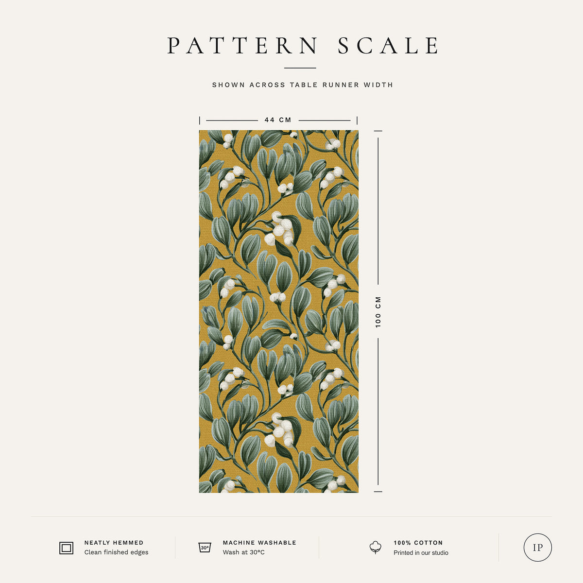 Pattern scale of the Mistletoe Christmas table runner in gold across its 44 cm width, with care notes