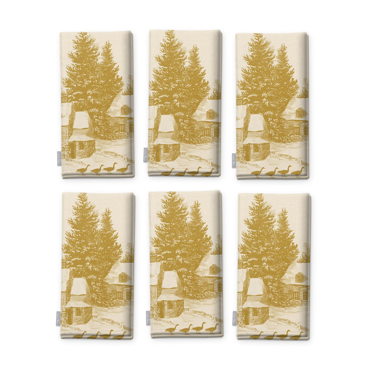 Village Toile Christmas napkins in gold on ivory, set of six, folded on white, showing the same fir tree and snowy cottage