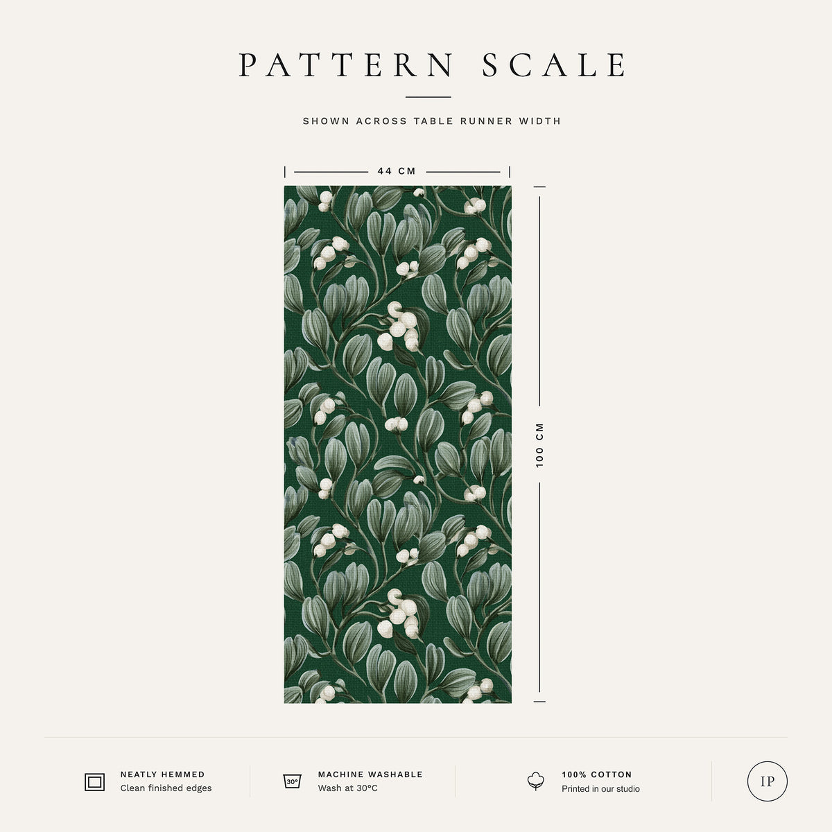 Pattern scale of the Mistletoe Christmas table runner in green across its 44 cm width, with care notes