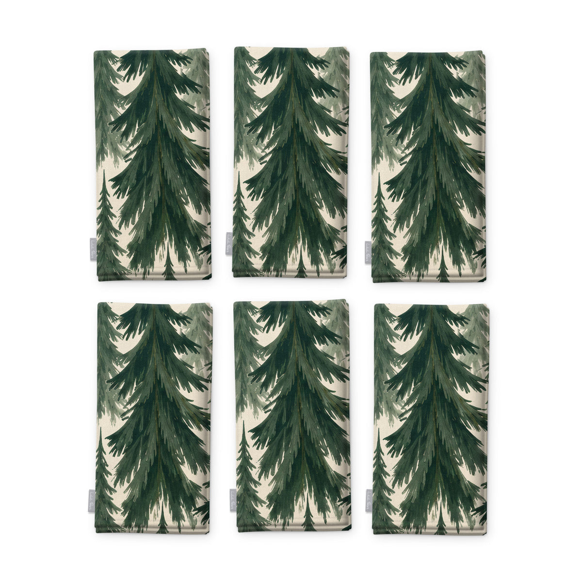 Spruce Stand Christmas napkins in green on ivory, set of six, folded on white, showing the same spruce trees