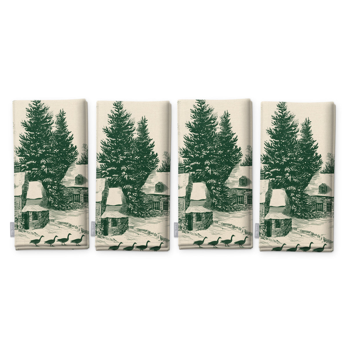 Village Toile Christmas napkins in green on ivory, set of four, folded on white, showing the same fir tree and snowy cottage