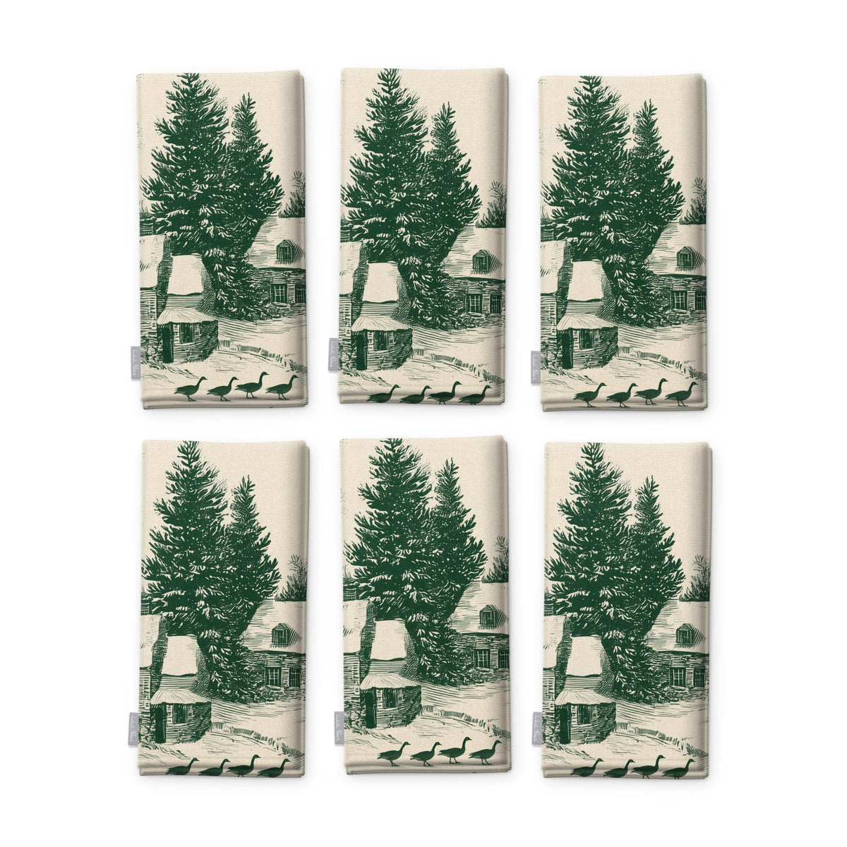 Village Toile Christmas napkins in green on ivory, set of six, folded on white, showing the same fir tree and snowy cottage