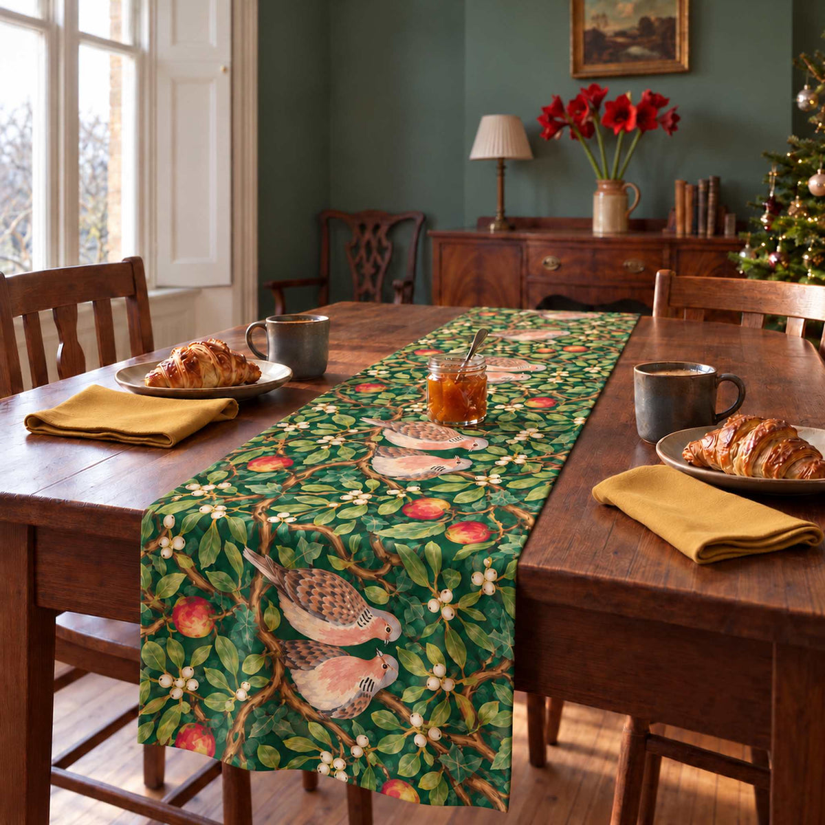 Turtle Doves and Mistletoe Christmas table runner in Green, styled on a wooden table with a softly draped end in a daylight Christmas room.