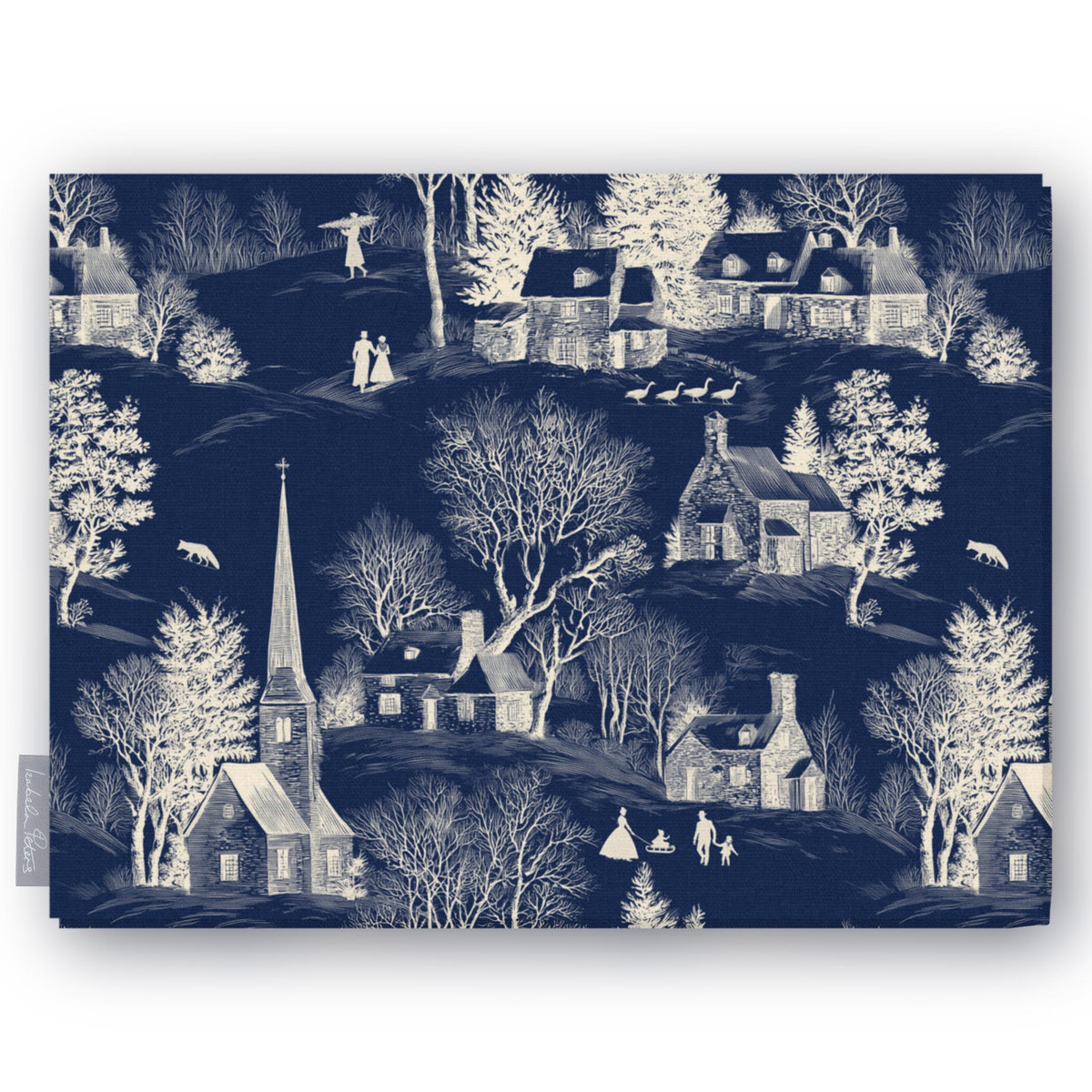 Village Toile Christmas tablecloth in ivory on navy, folded on white, showing a snowy village with a church and cottages