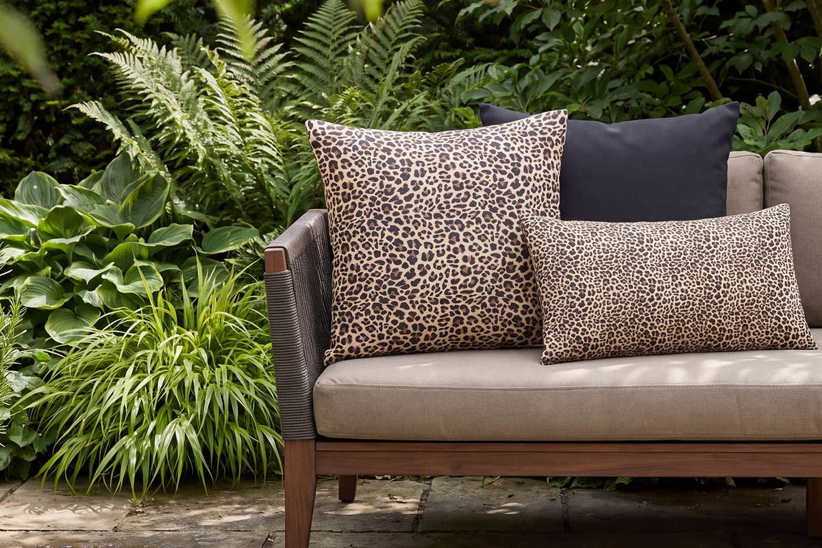 Leopard-print outdoor cushions in square and rectangular sizes styled on a garden sofa
