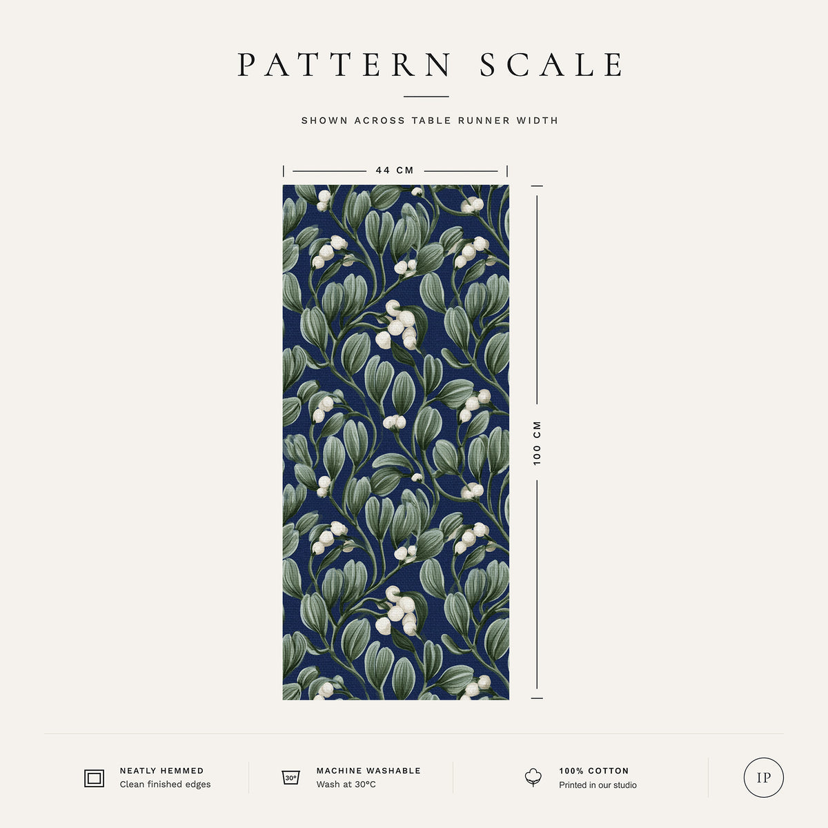 Pattern scale of the Mistletoe Christmas table runner in navy across its 44 cm width, with care notes