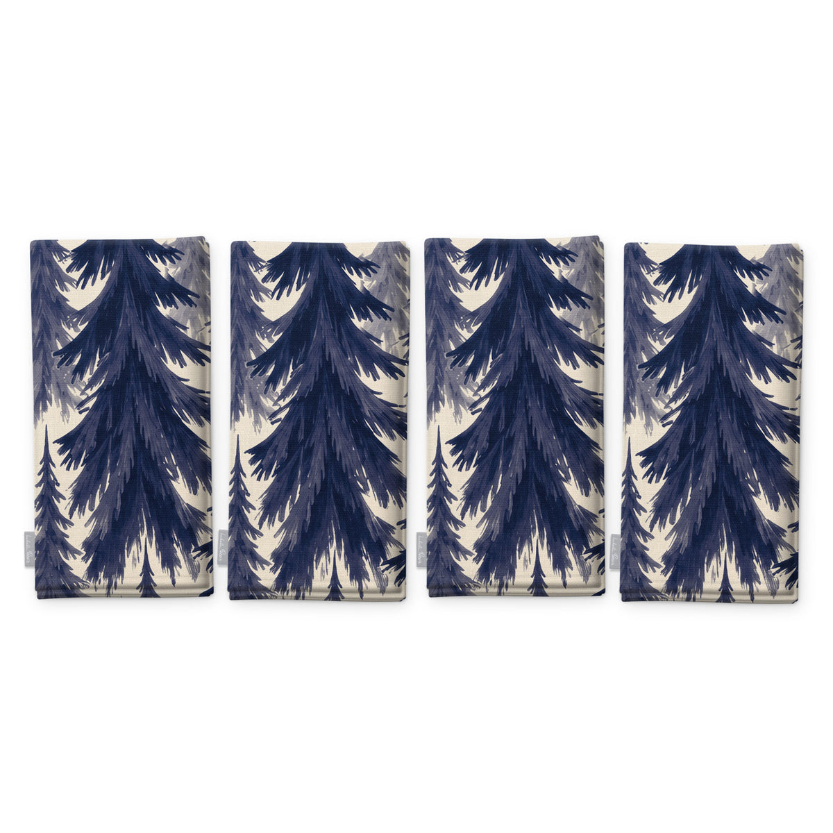 Spruce Stand Christmas napkins in navy on ivory, set of four, folded on white, showing the same spruce trees