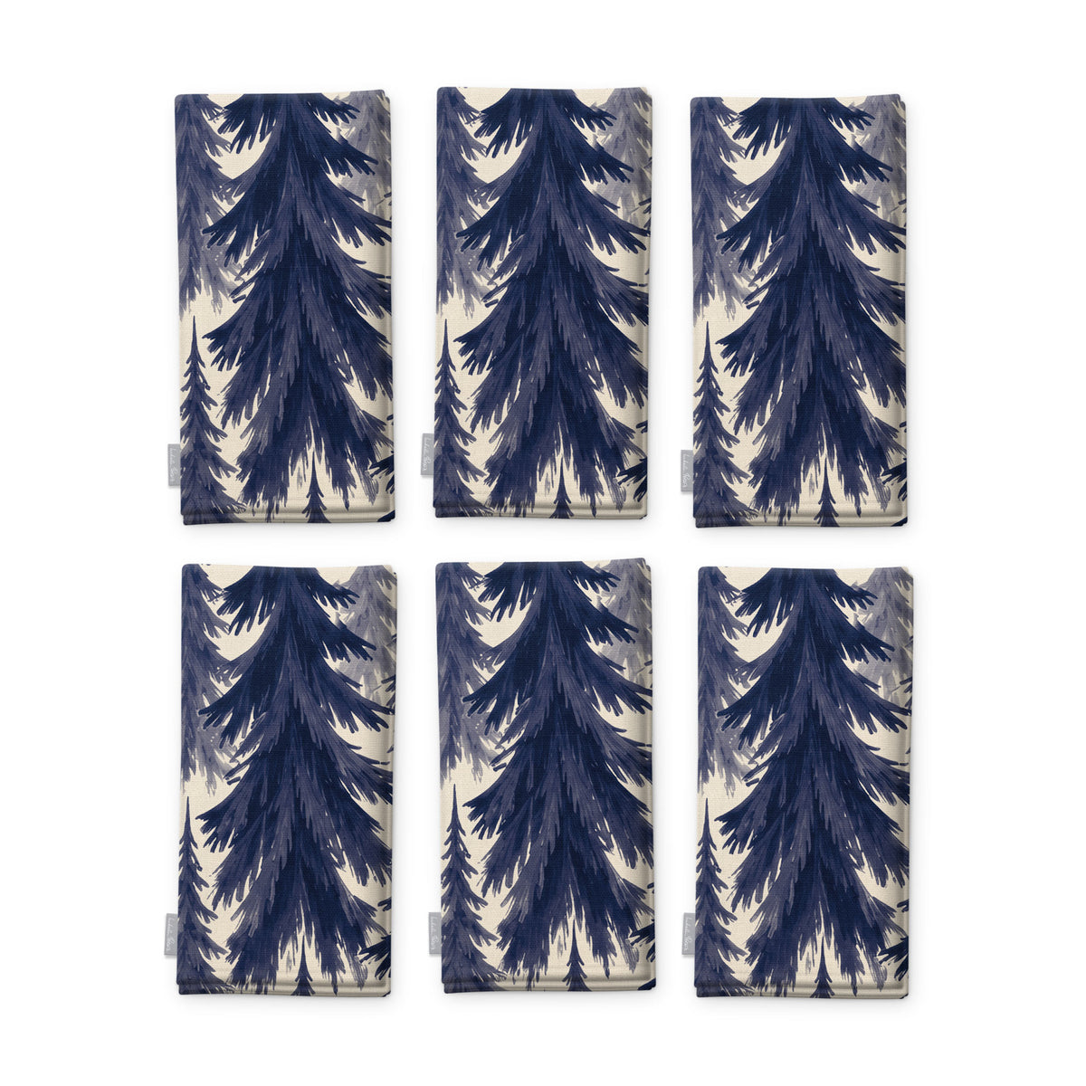 Spruce Stand Christmas napkins in navy on ivory, set of six, folded on white, showing the same spruce trees