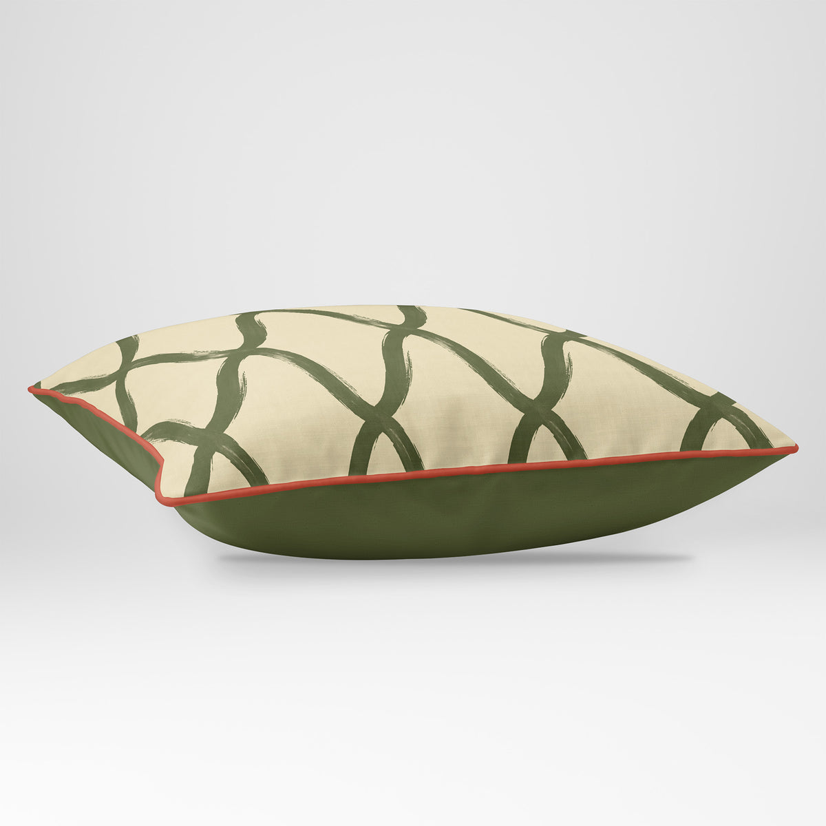 Angled view showing the front and Deep Olive plain reverse of a Palace Trellis rectangular cushion in Olive & Tomato, finished with Tomato piping.