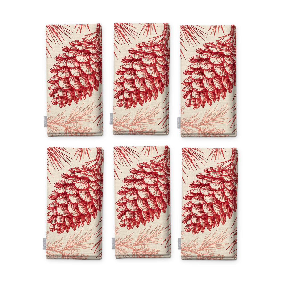 Pine Bough Christmas napkins in red on ivory, set of six, folded on white, showing the same pine cone on a bough