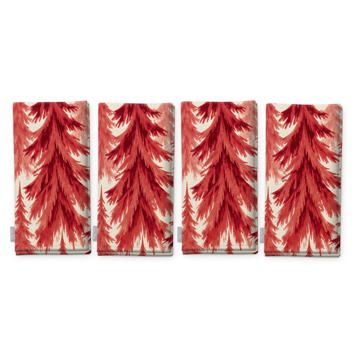 Spruce Stand Christmas napkins in red on ivory, set of four, folded on white, showing the same spruce trees