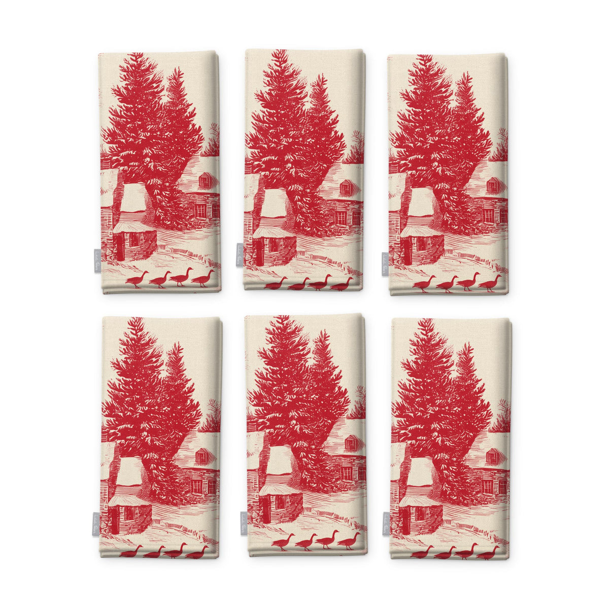 Village Toile Christmas napkins in red on ivory, set of six, folded on white, showing the same fir tree and snowy cottage