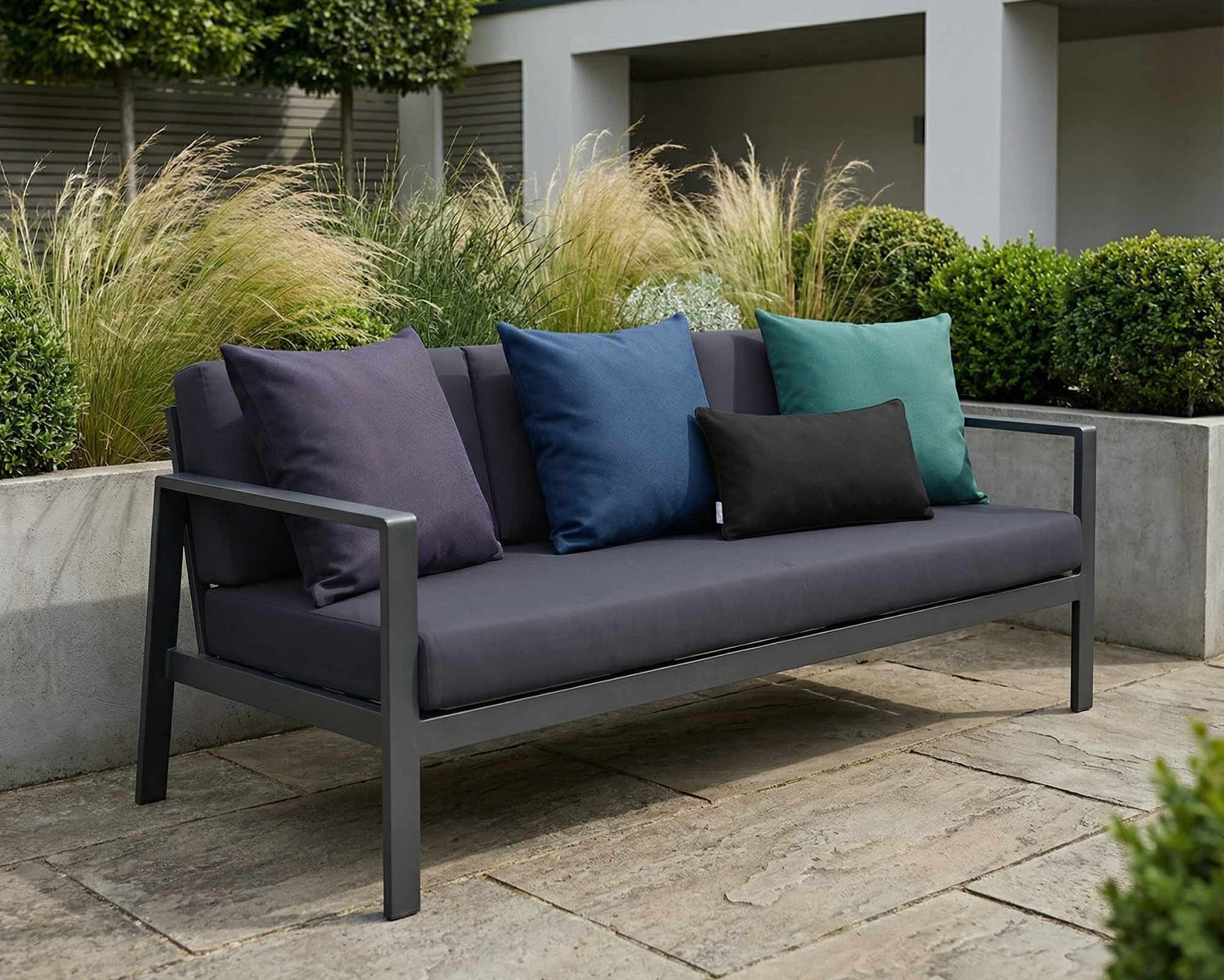 odern outdoor sofa styled with signature colour waterproof cushions in a contemporary British garden setting