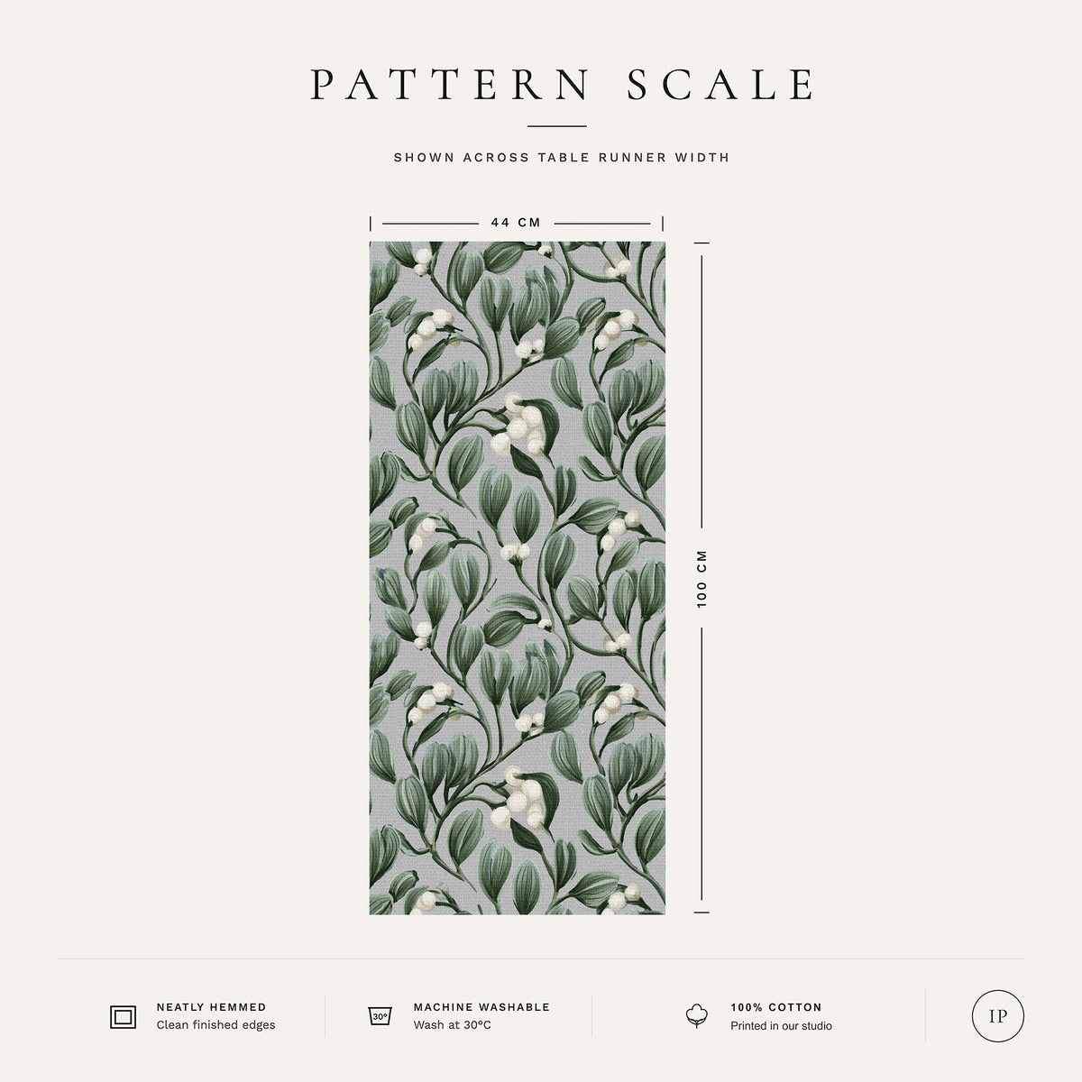 Pattern scale of the Mistletoe Christmas table runner in silver grey across its 44 cm width, with care notes