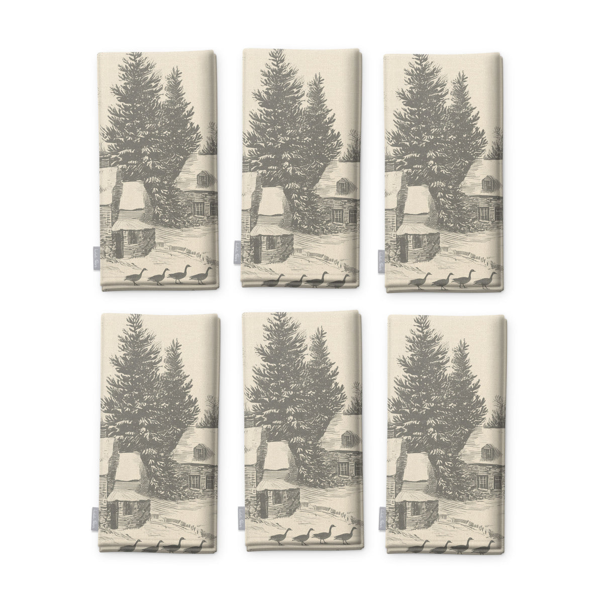 Village Toile napkins in silver grey on ivory, set of six, folded on white, showing the same fir tree and snowy cottage