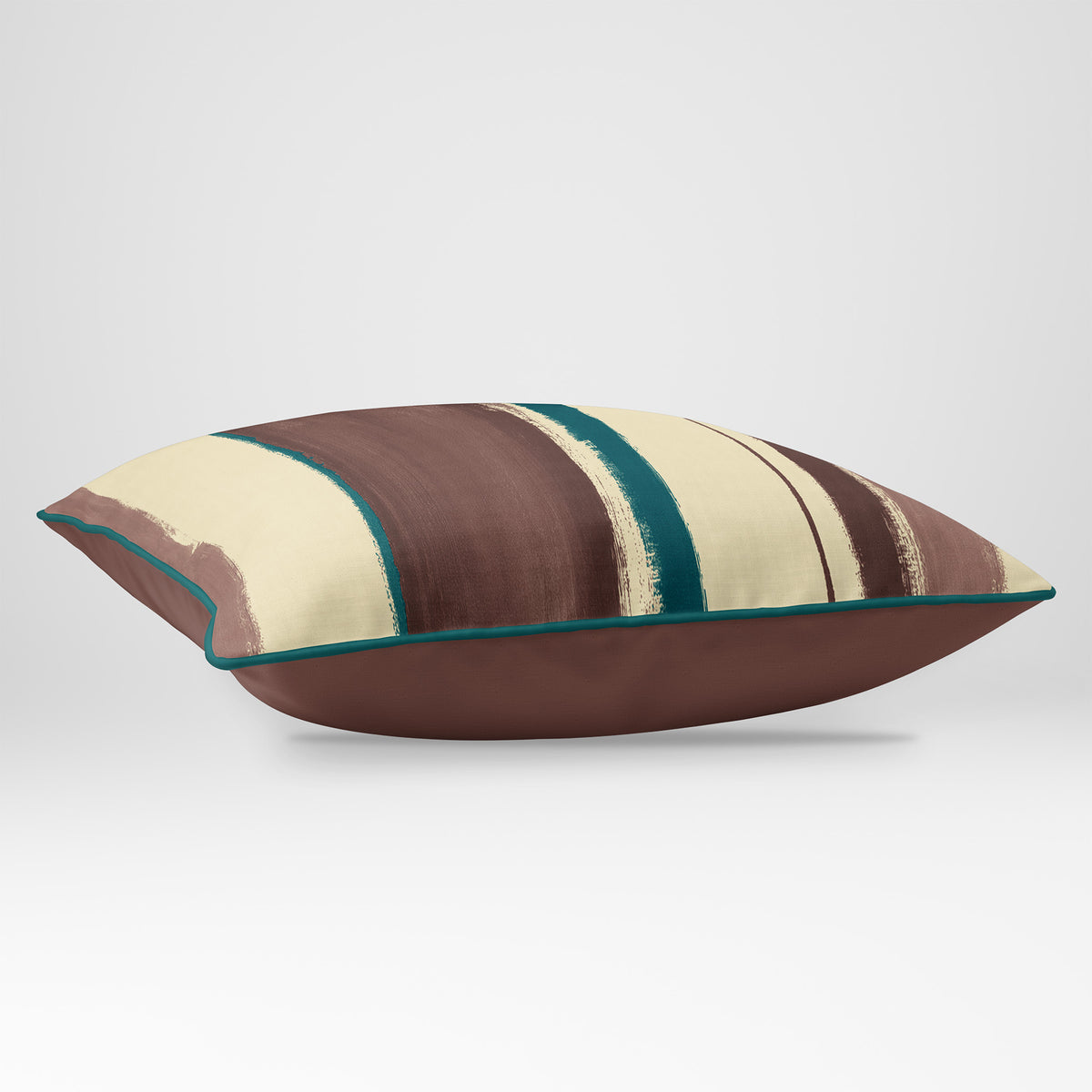 Angled view showing the front and Cocoa plain reverse of an Unequal Stripe rectangular cushion in Cocoa & Teal, finished with Deep Teal piping.