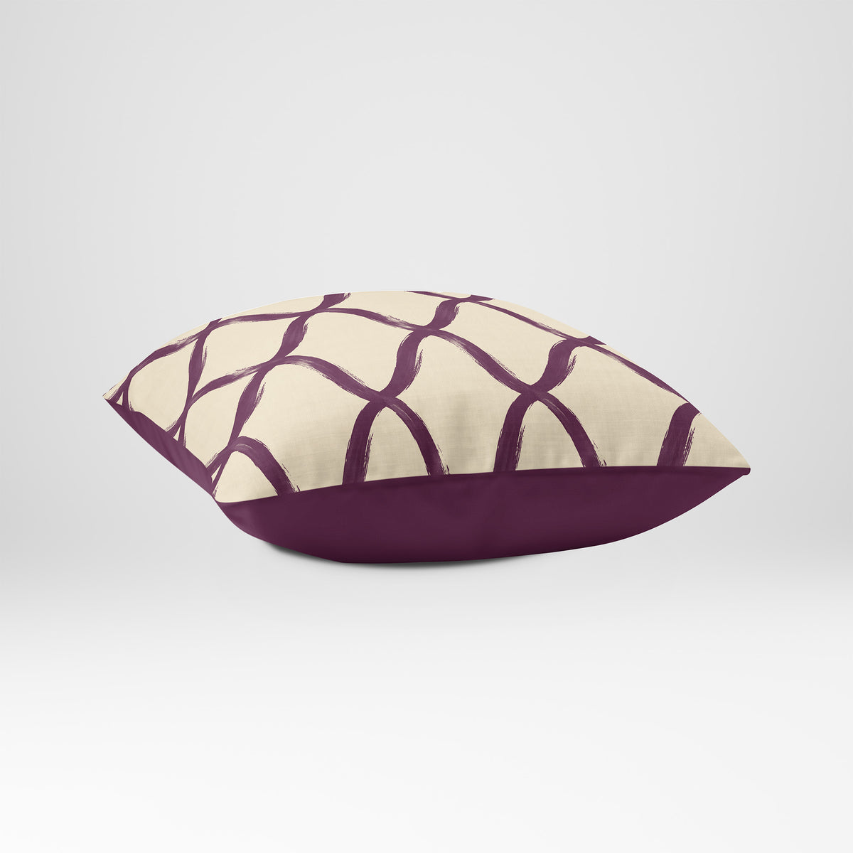 Angled view showing the front and Rich Plum plain reverse of a Palace Trellis square cushion in Plum & Saffron, with a plain sewn edge.