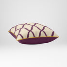 Angled view showing the front and Rich Plum plain reverse of a Palace Trellis square cushion in Plum & Saffron, finished with Saffron piping.