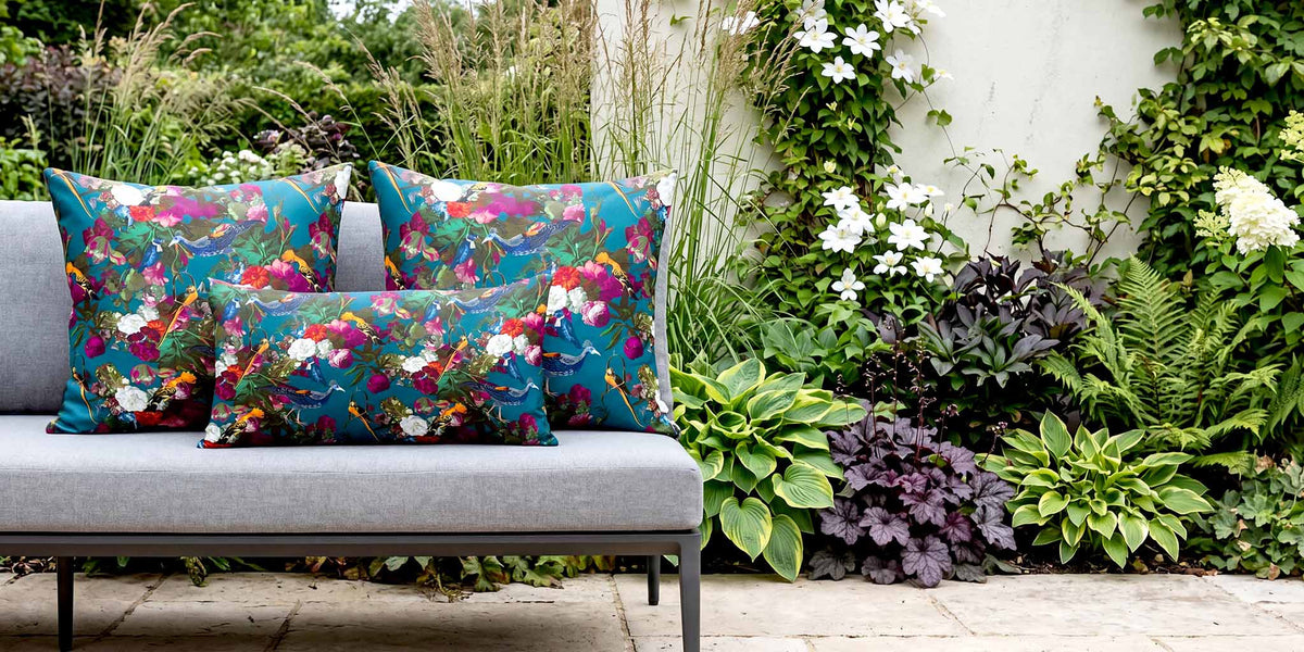 Teal Manor House Garden bird outdoor cushions on a contemporary grey garden sofa.