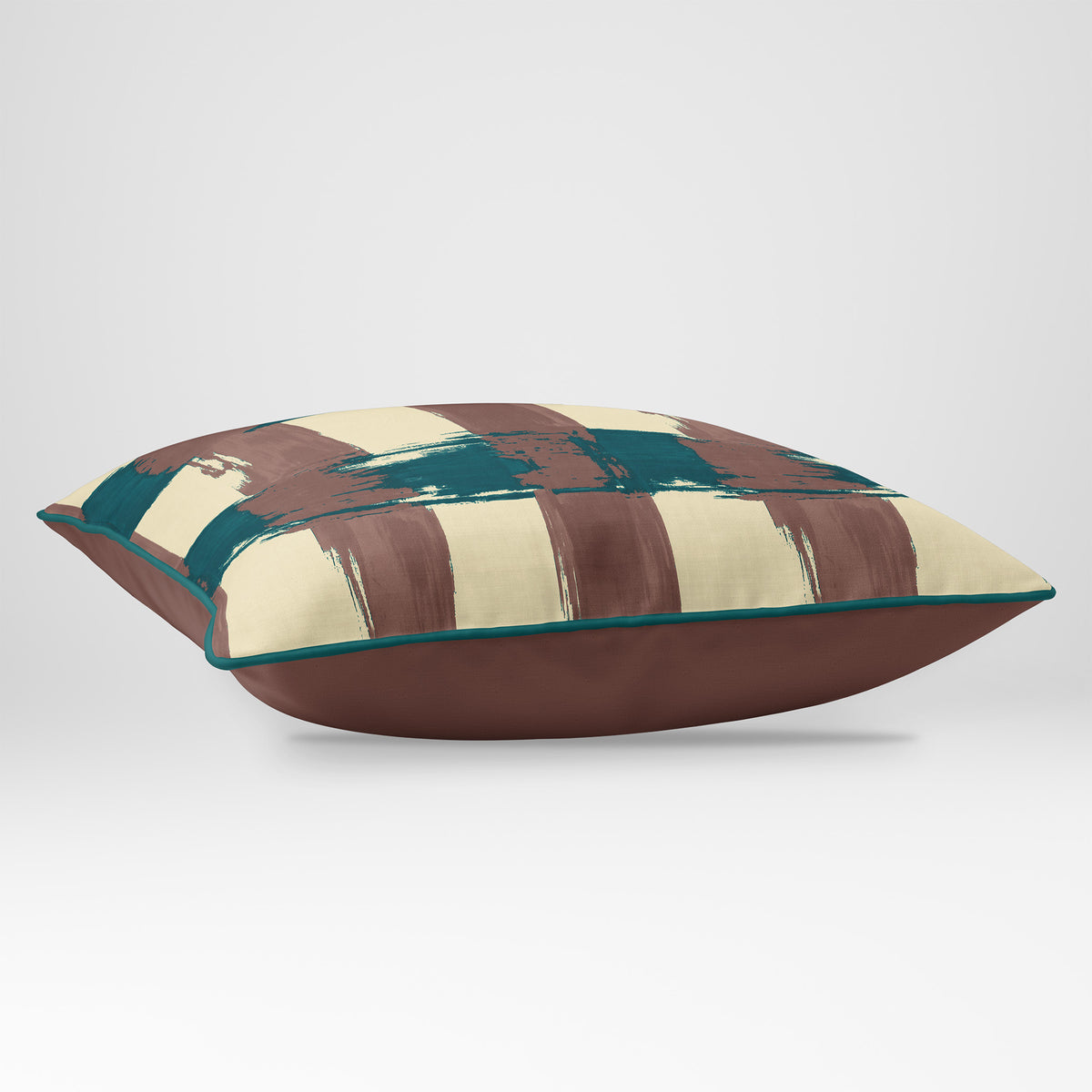 Angled view showing the front and Cocoa plain reverse of a Broad Check rectangular cushion in Cocoa & Teal, finished with Deep Teal piping.