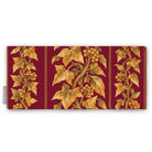 Gilded Ivy Christmas table runner in burgundy and gold, folded on white, showing trails of gold ivy and berries