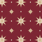 Close-up of the Stars Christmas tablecloth print in burgundy and gold on cotton, showing gold eight-pointed stars