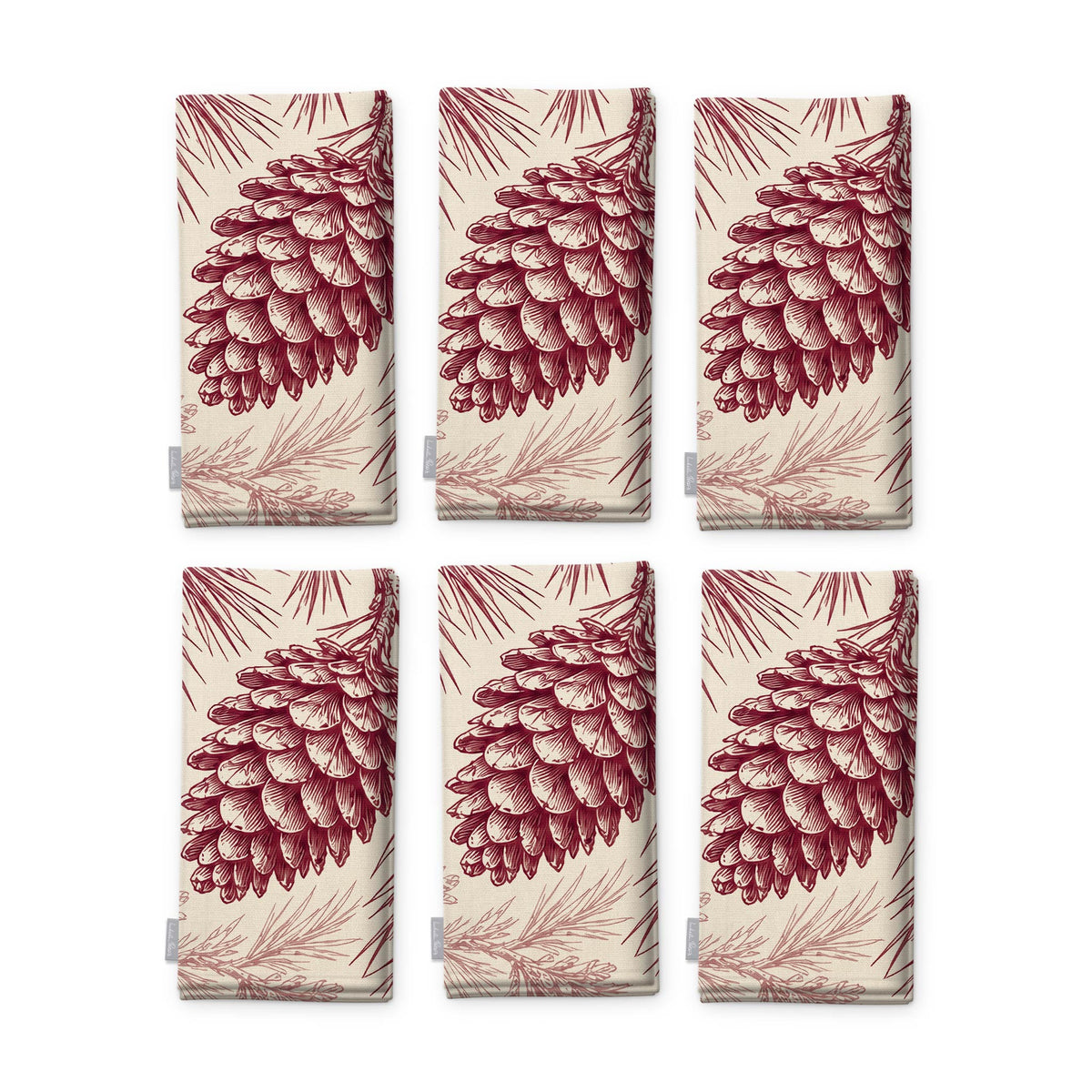 Pine Bough Christmas napkins in burgundy on ivory, set of six, folded on white, showing the same pine cone on a bough