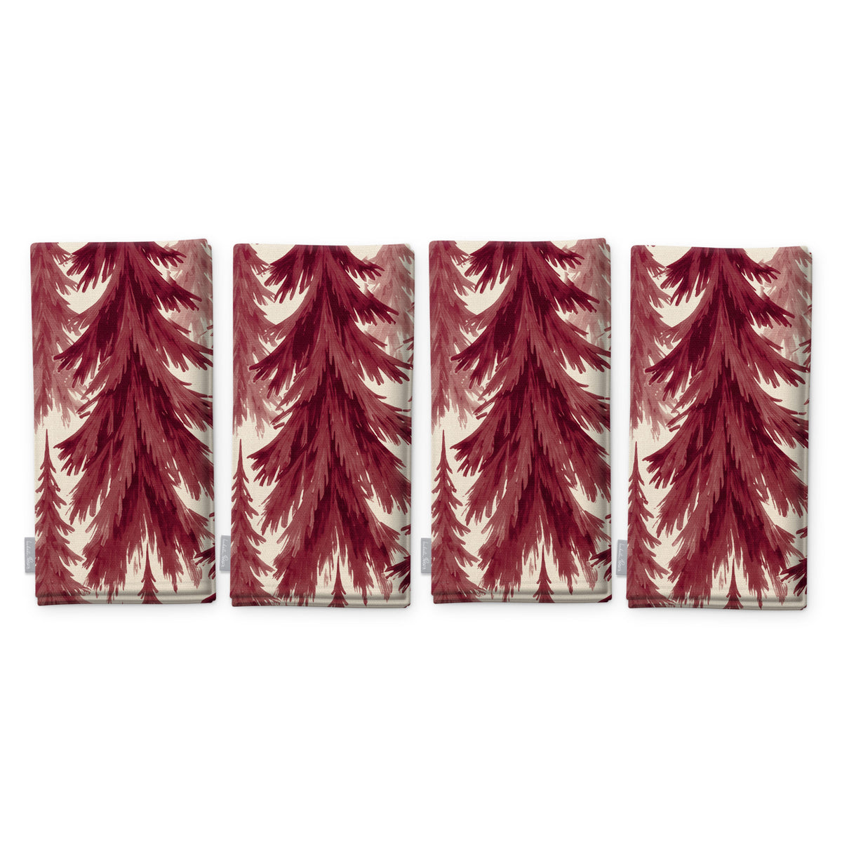 Spruce Stand Christmas napkins in burgundy on ivory, set of four, folded on white, showing the same spruce trees