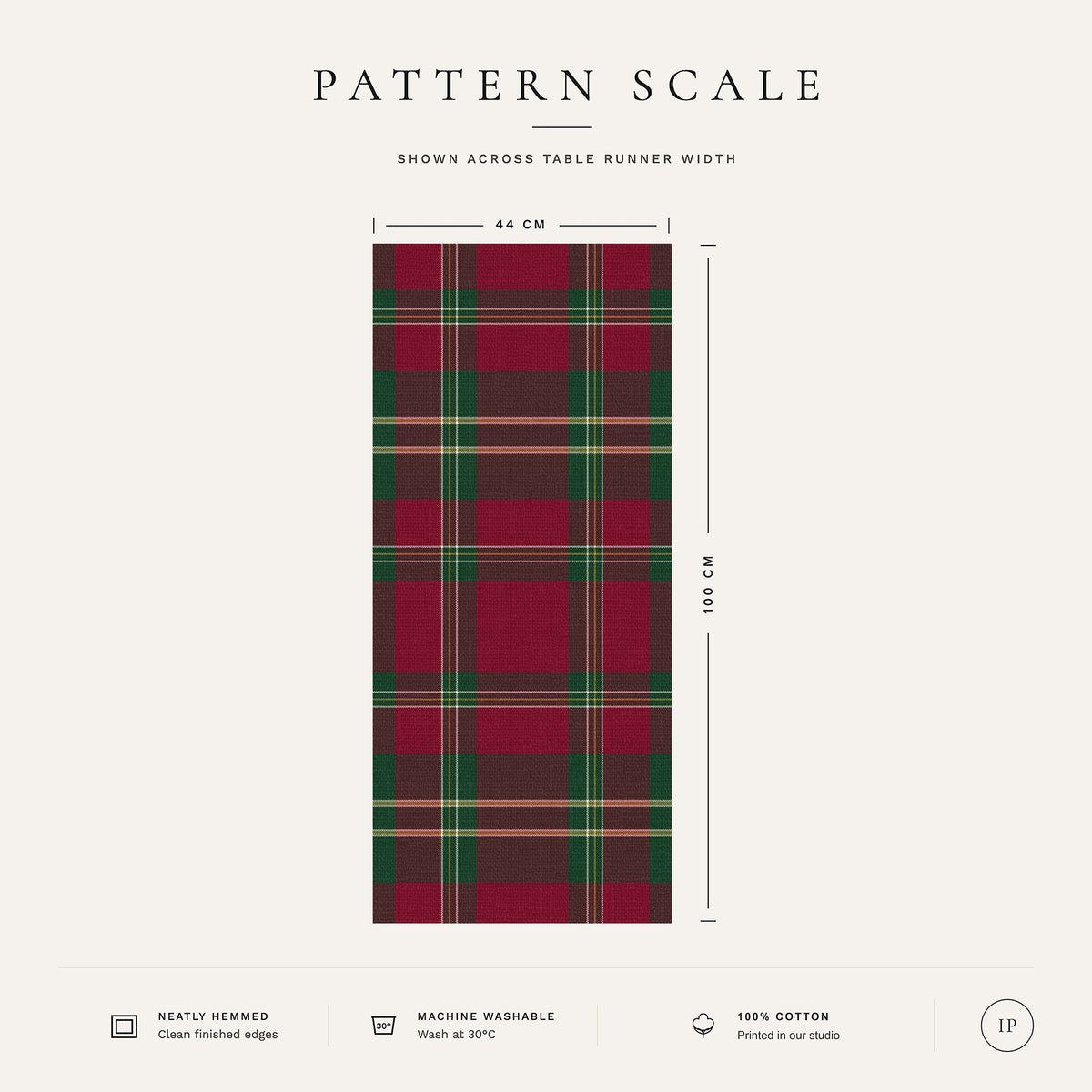 Pattern scale of the Tartan Christmas table runner in burgundy across its 44 cm width, with care notes
