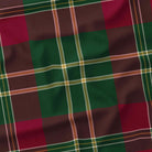 Close-up of the burgundy tartan Christmas tablecloth, showing the burgundy and deep green check and fine ivory and gold lines