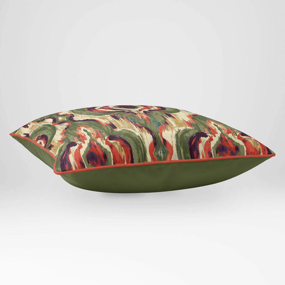 Angled view showing the front and Deep Olive plain reverse of a Court Medallion rectangular cushion in Olive & Tomato, finished with Tomato piping.