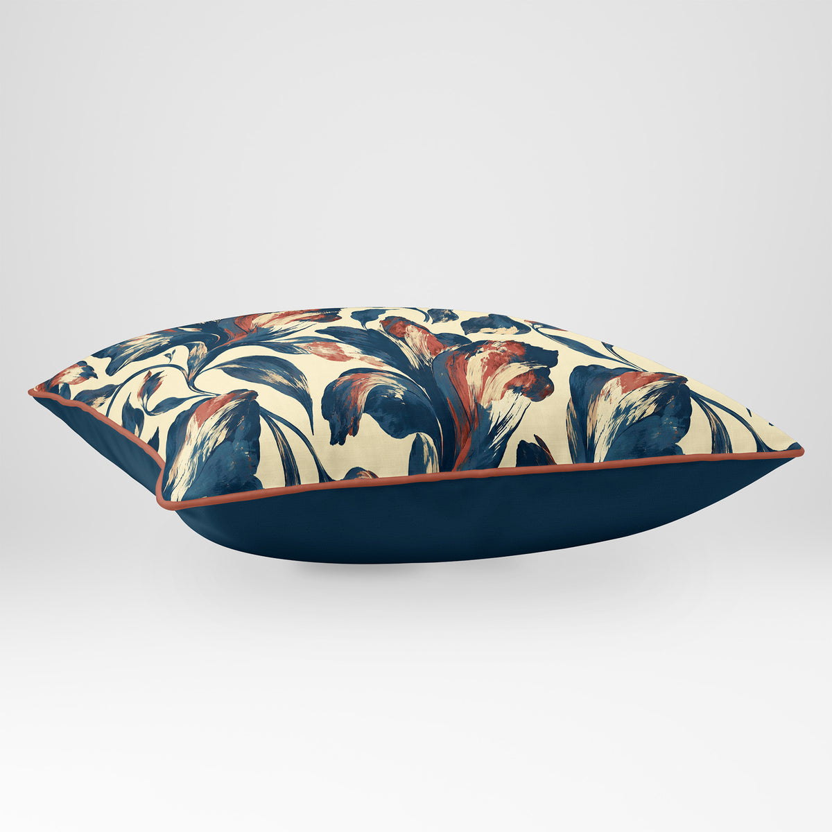 Angled view showing the front and Deep Teal plain reverse of a Fiora Floral rectangular cushion in Teal & Persimmon, finished with Persimmon piping.