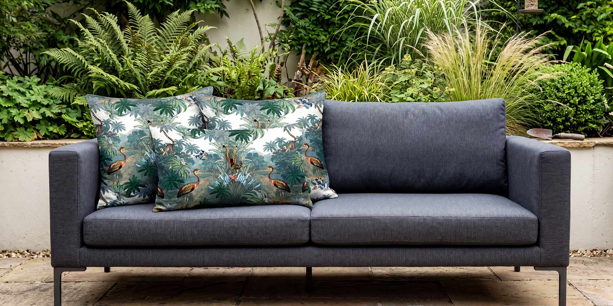 Kilimanjaro flora and fauna outdoor cushions on a charcoal grey garden sofa.