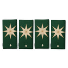 Stars Christmas napkins in green and gold, set of four, folded on white, showing the same large gold eight-pointed star