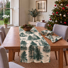 Fir Forest Toile Christmas table runner in Green on ivory, styled on a wooden table with a softly draped end in a daylight Christmas room.