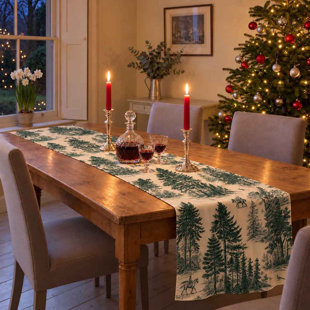 Fir Forest Toile Christmas table runner in Green on ivory, styled on a wooden table with a softly draped end in a candlelit Christmas room.