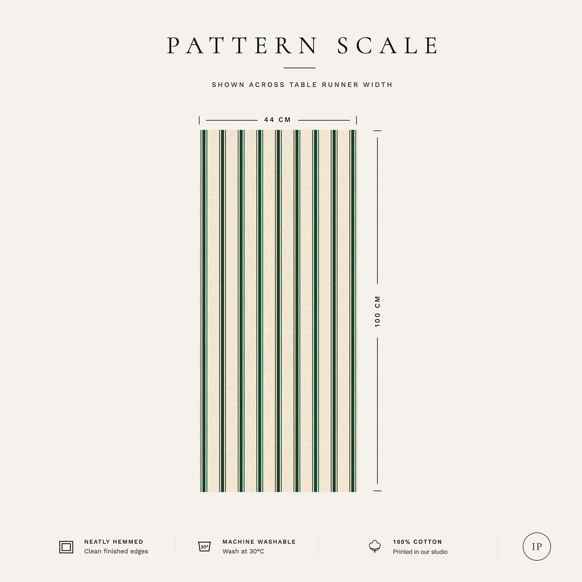 Pattern scale of the Ticking Stripe Christmas table runner in green on ivory across its 44 cm width, with care notes