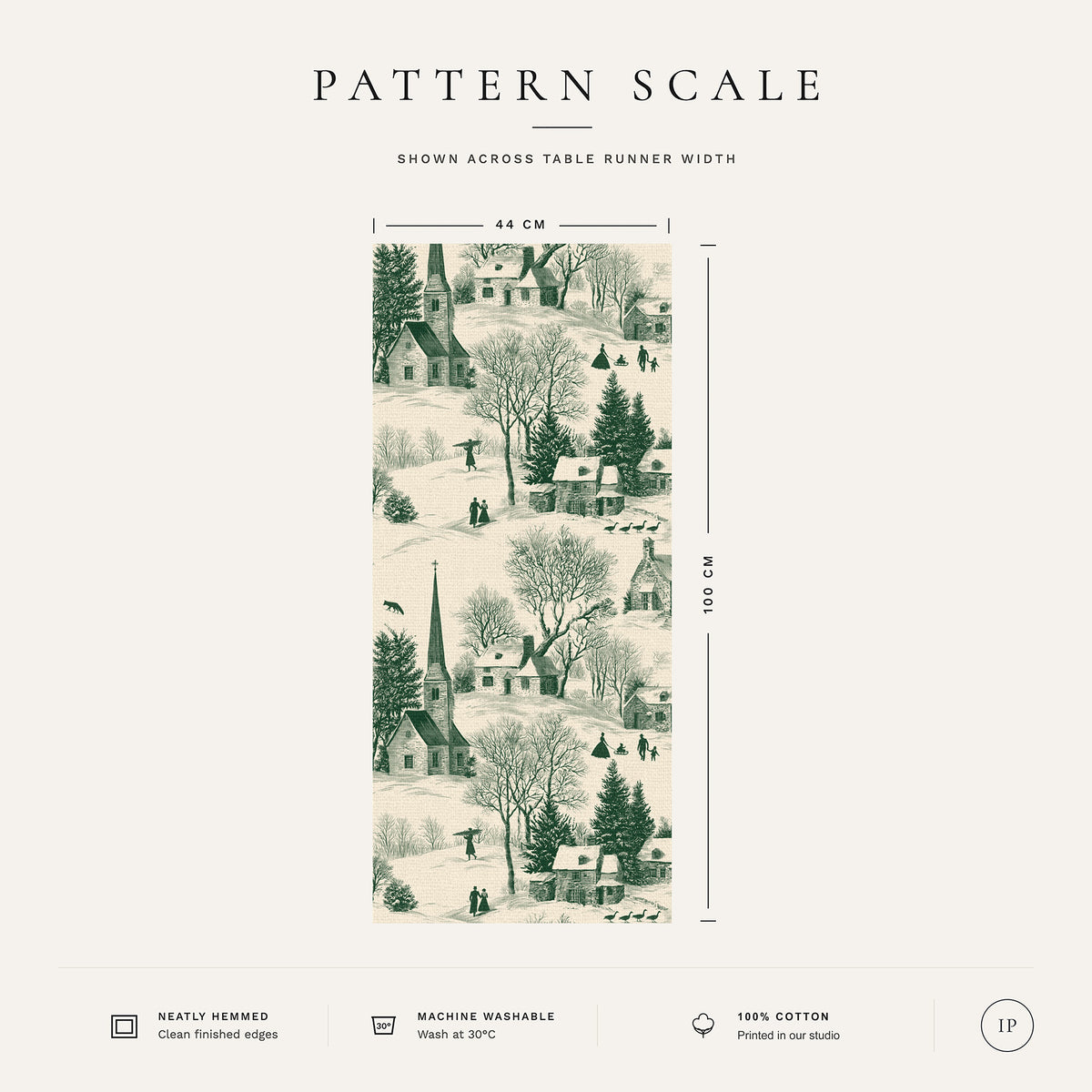 Pattern scale of the Village Toile Christmas table runner in green on ivory across its 44 cm width, with care notes