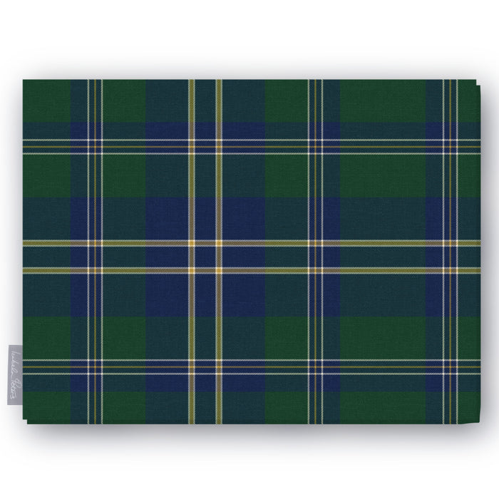 Green tartan Christmas tablecloth folded on a white background, green and navy with fine ivory and gold lines