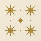 Close-up of the Stars Christmas napkin print in ivory and gold on cotton, showing gold eight-pointed stars