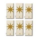 Stars Christmas napkins in ivory and gold, set of six, folded on white, showing the same large gold eight-pointed star